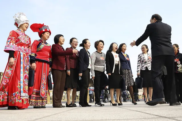 Female delegates prepare for a group photo to mark International Women's Day outside the Great Hall of the People where a session of the National People's Congress is held in Beijing Friday, March 8, 2019. (Photo by Ng Han Guan/AP Photo)