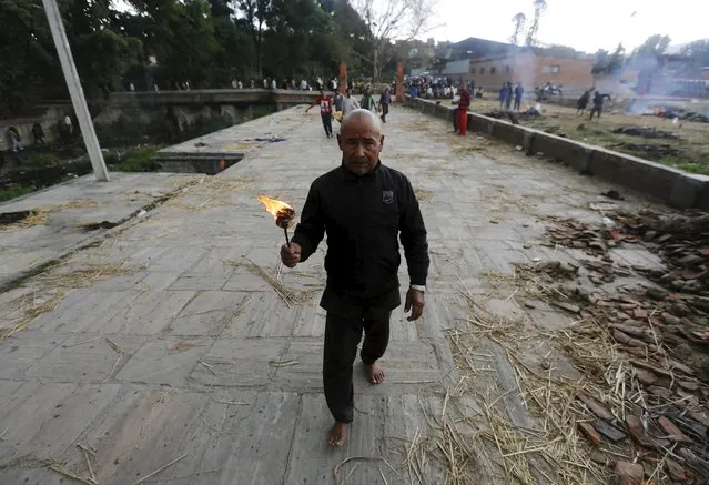 A man performs last rites of a family member at a cremation ground after an earthquake in Bhaktapur, Nepal April 27, 2015. (Photo by Adnan Abidi/Reuters)