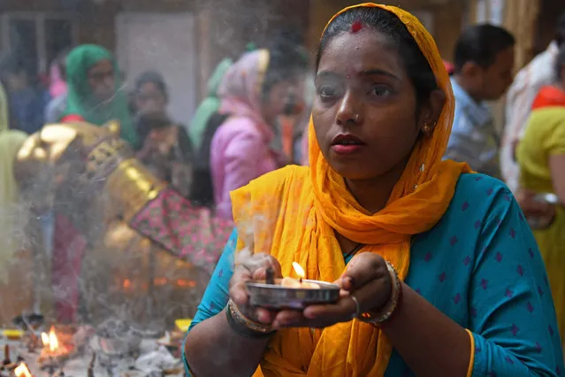 A devotee offers prayers on the first day of 'Navratri' or the nine nights Hindu festival that symbolises the triumph of good over evil at the Mata Longa Wali Devi temple in Amritsar on October 7, 2021. (Photo by Narinder Nanu/AFP Photo)