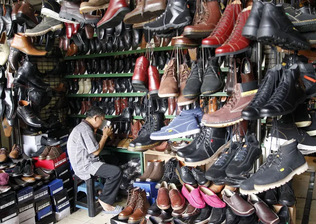 A vendor waits for customers at a shoe stall in Jakarta, Indonesia March 3, 2016. (Photo by Garry Lotulung/Reuters)