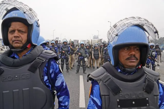 Rapid Action Force personnel guard a major highway at Singhu near New Delhi to stop thousands of protesting farmers from entering the capital, India, Tuesday, February 13, 2024. Farmers, who began their march from northern Haryana and Punjab states, are asking for a guaranteed minimum support price for all farm produce. (Photo by Manish Swarup/AP Photo)
