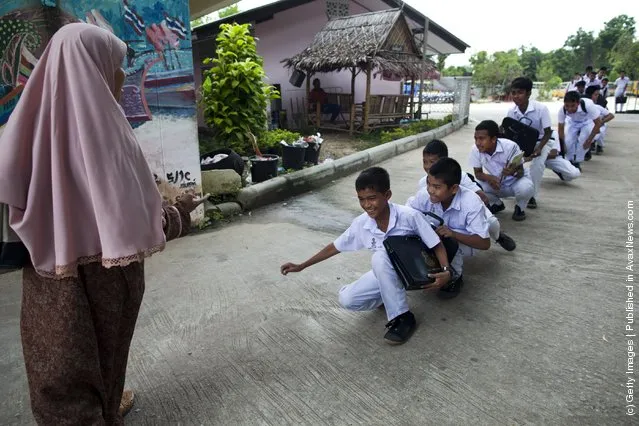 Islamic boys are told to walk like a duck as a punishment for being late to school at the Darunsat Wittaya school