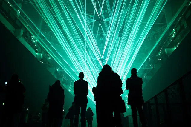 People visit a preview of the audio-visual light installation VEKTOR by artist Christopher Bauder at Kraftwerk in Berlin, Germany, on February 1, 2024. (Photo by Liesa Johannssen/Reuters)