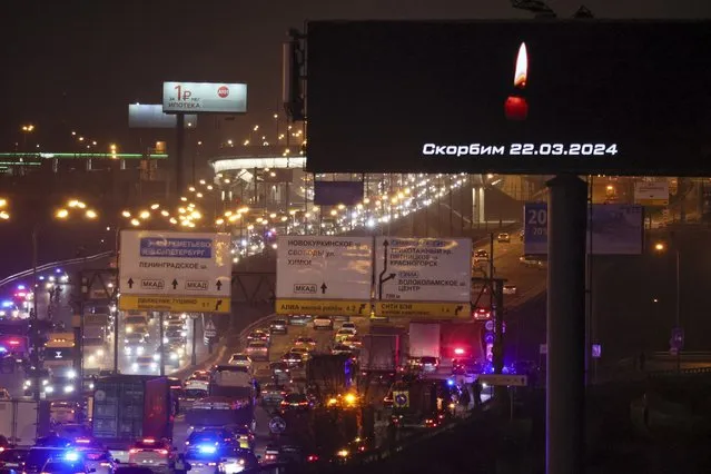 Traffic on the highway is visible near the Crocus City Hall with a warning message on a billboard that reads “we mourn 03.22.2024” on the western edge of Moscow, Russia, Friday, March 22, 2024. Several gunmen have burst into a big concert hall in Moscow and fired automatic weapons at the crowd, injuring an unspecified number of people and setting a massive blaze in an apparent terror attack days after President Vladimir Putin cemented his grip on the country in a highly orchestrated electoral landslide. (Photo by Vitaly Smolnikov/AP Photo)