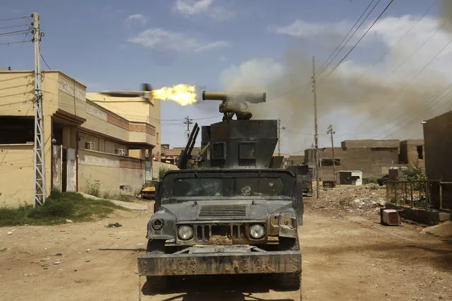 Iraq's elite counterterrorism forces fire towards extremist positions during fights between Iraqi security forces and Islamic State group during a military operation to regain control of Hit, 85 miles (140 kilometers) west of Baghdad, Iraq, Wednesday, April 13, 2016. (Photo by Khalid Mohammed/AP Photo)