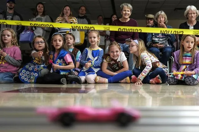 Girl Scout Daisys watch a car race during the Girl Scouts Pinewood Derby, Saturday, April 13, 2024, in Marietta, Ga. (Photo by Mike Stewart/AP Photo)