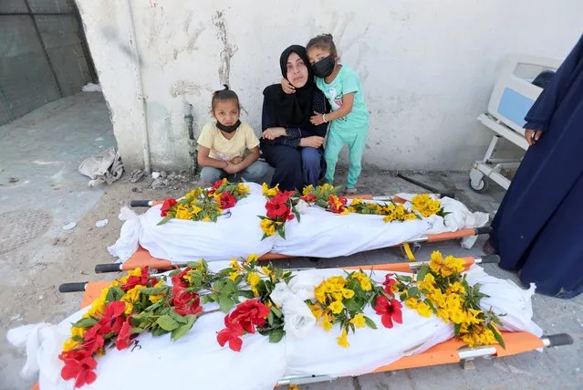 Mourners react as people work to move bodies of Palestinians killed during Israel's military offensive and buried at Nasser hospital into a cemetery, amid the ongoing conflict between Israel and the Palestinian Islamist group Hamas, in Khan Younis in the southern Gaza Strip, on April 21, 2024. (Photo by Ramadan Abed/Reuters)
