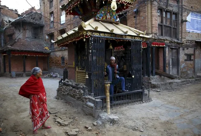 A man walks out from a temple near a damaged house after offering daily prayers in the temple after the April 25 earthquake in Kathmandu, Nepal May 25, 2015. (Photo by Navesh Chitrakar/Reuters)