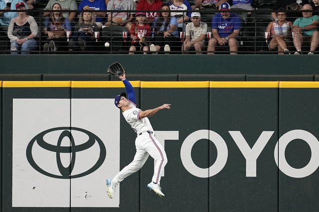Texas Rangers left fielder Wyatt Langford makes a leaping catch on a fly out by Seattle Mariners' Mitch Haniger in the first inning of a baseball game in Arlington, Texas, Thursday, April 25, 2024. (Photo by Tony Gutierrez/AP Photo)