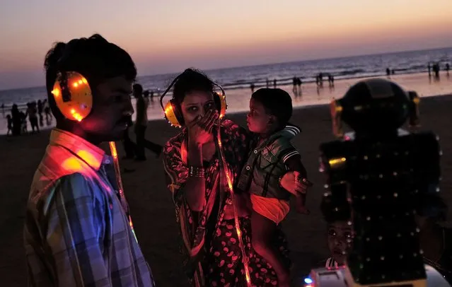 A woman reacts as she listens to a fortune telling machine at a beach along the Arabian Sea in Mumbai April 2, 2014. (Photo by Danish Siddiqui/Reuters)