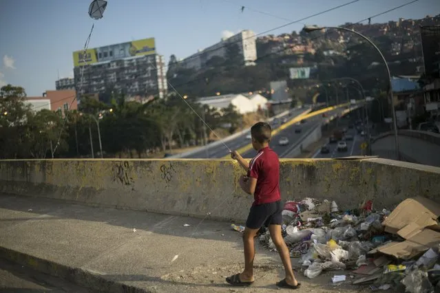 A boy flies a kite in Caracas, Venezuela, Tuesday, February 5, 2019. Earlier this year, opposition leader Juan Guaidó launched a bold campaign with the support of the U.S. and more than 50 nations to oust Chávez’s successor, President Nicolás Maduro. However, Guaidó has yet to make good on his promises to restore democracy, spark a robust economy and make the streets safer. (Photo by Rodrigo Abd/AP Photo)
