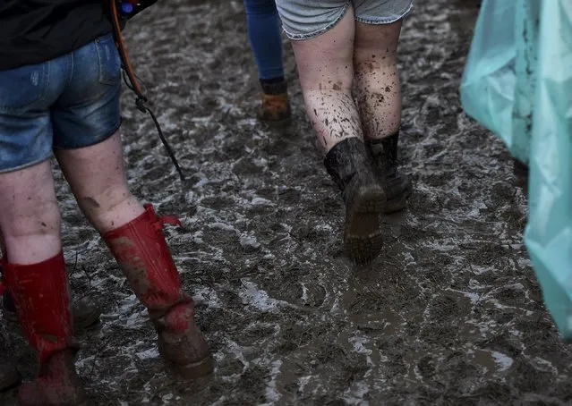 Revellers walk on muddy ground during the Glastonbury Festival at Worthy Farm in Somerset, Britain, June 26, 2015. (Photo by Dylan Martinez/Reuters)