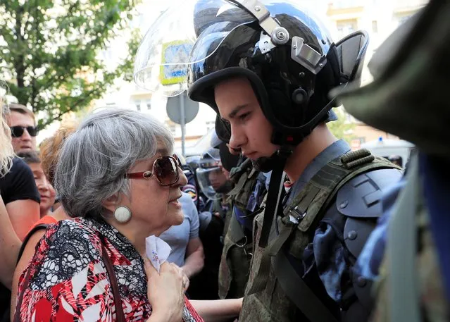 A woman talks with a law enforcement officer during a rally calling for opposition candidates to be registered for elections to Moscow City Duma, the capital's regional parliament, in Moscow, July 27, 2019. (Photo by Tatyana Makeyeva/Reuters)