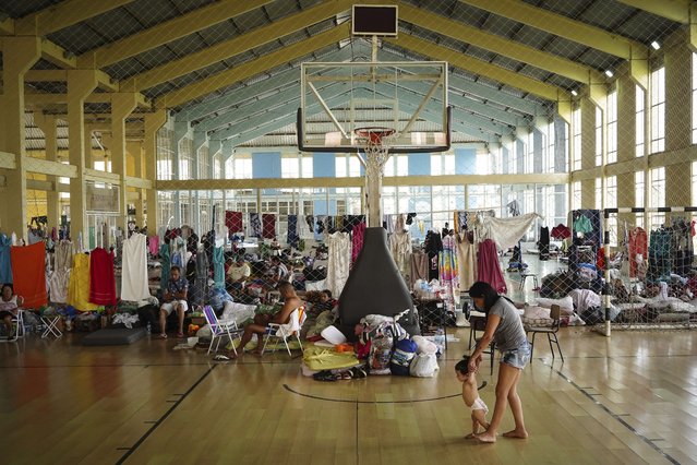 Residents rest in a gymnasium converted into a shelter for people whose homes were flooded by heavy rains, in Canoas, Rio Grande do Sul state, Brazil, May 8, 2024. (Photo by Carlos Macedo/AP Photo)