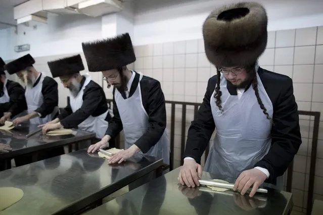 Ultra-Orthodox Jews knead dough in a matzah bakery in the Belz Hasidic dynasty in Jerusalem, Israel, 14  April 2014, as part of the preparation for the high holiday of Passover at sunset this evening. Religious Jewish families as well store and restaurant owners removed all traces of “chametz” (unleavened food) prior to the Passover feast, which commemorates the Israelites' exodus from ancient Egypt. (Photo by Abir Sultan/EPA)