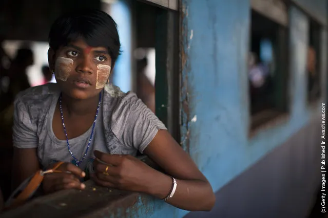 A Burmese woman sits on board a local train waiting for it to depart the Yangon station