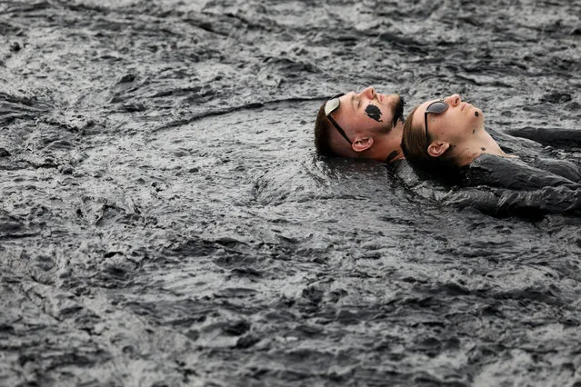 People take a mud bath during the “Iron mud” festival in the town of Zheleznovodsk, in Stavropol region, Russia on August 24, 2019. (Photo by Eduard Korniyenko/Reuters)