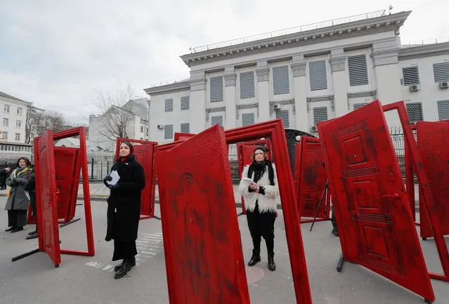 Ukrainian and Crimean Tatar's activists perform with doors in front of the Russian Embassy in Kiev, 21 February 2022. Eleven broken doors were installed as a symbol of 11 broken lives of civic journalists and Crimean Tatars in front of the Russian Embassy. More than a hundred activists and Crimean Tatars have been detained by the Russian authority for their civic stance since the annexation of Crimea in 2014. (Photo by Sergey Dolzhenko/EPA/EFE)