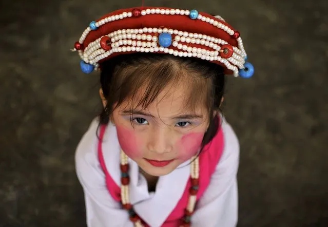 A Tibetan girl in a traditional costume waits backstage before performing at celebrations marking the 80th birthday celebrations of the Tibetan spiritual leader the Dalai Lama, at the Sera Jey Monastery in Bylakuppe in the southern state of Karnataka, India, July 6, 2015. (Photo by Abhishek N. Chinnappa/Reuters)