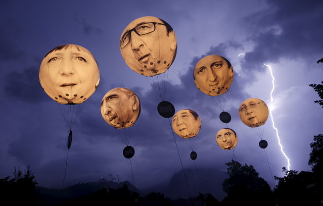 Lightning strikes the Alpine mountains over Garmisch-Partenkirchen as balloons, made by the “ONE” campaigning organisation, depicting leaders of the G7 countries are inflated in Garmisch-Partenkirchen June 7, 2015. (Photo by Wolfgang Rattay/Reuters)