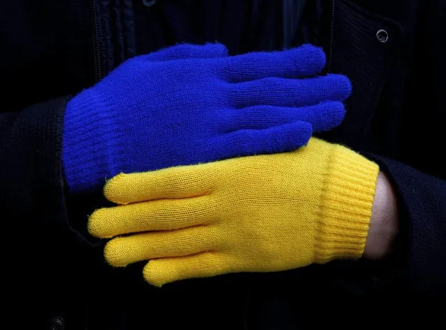A protester wears a pair of gloves in the colours of the Ukraine's national flag during a march to protest against Russia's invasion of Ukraine, in Tokyo, Japan, March 5, 2022. (Photo by Kim Kyung-Hoon/Reuters)