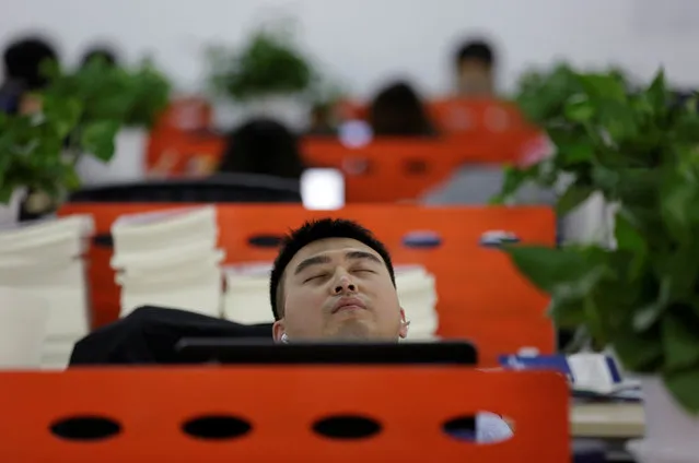 Cui Meng, a Co-founder of Goopal Group, takes a nap in his seat after lunch, in Beijing, China, April 21, 2016. (Photo by Jason Lee/Reuters)