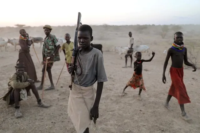 A young Turkana warrior arrives with cattle to a settlement in Ilemi Triangle, Kenya, July 20, 2019. The Ilemi Triangle, a disputed sliver of land along the border with Ethiopia and South Sudan, is the northernmost tip of Turkana, Kenya's poorest county. A series of deadly clashes between the Turkana community and other ethnic groups that they said had crossed from South Sudan have put people on edge, to the point of posting lookouts. (Photo by Goran Tomasevic/Reuters)