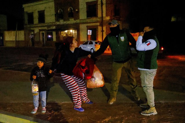 A migrant from Venezuela, in the company of her daughter, is pulled during an operation by agents from Mexico's National Institute of Migration (INM) and the police in downtown Ciudad Juarez, Mexico on March 13, 2023. (Photo by Jose Luis Gonzalez/Reuters)