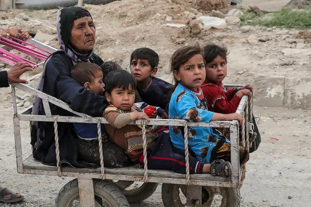 A displaced Iraqi woman and children are transported in a cart as the battle between the Iraqi Counter Terrorism Service and Islamic State militants continues nearby, in western Mosul, Iraq, April 23, 2017. (Photo by Marko Djurica/Reuters)