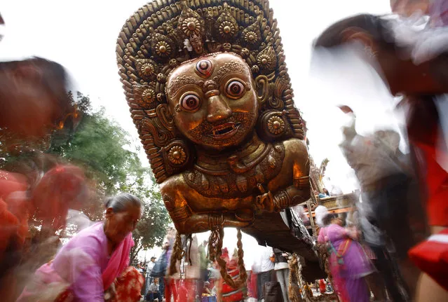Devotees offer prayer on the mask of Bhairab kept on the chariot of Rato Machhindranath during the chariot festival in Lalitpur, Nepal, May 17, 2016. Rato Machhindranath is known as the god of rain and both Hindus and Buddhists worship Machhindranath for good rain to prevent drought during the rice harvest season. Picture taken with slow shutter speed. (Photo by Navesh Chitrakar/Reuters)