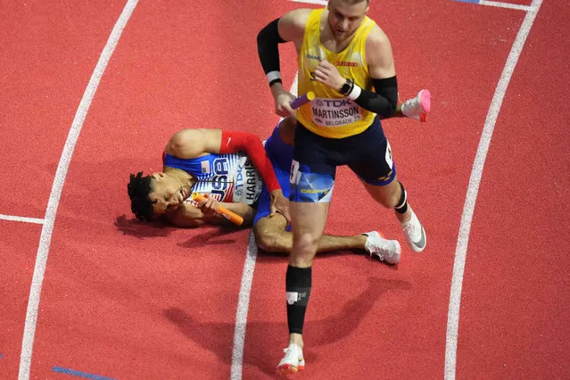 Isaiah Harris, of the United States, falls to the ground holding his thigh as he crosses the finish line in a Men's 4 X 400 meters heat at the World Athletics Indoor Championships in Belgrade, Serbia, Sunday, March 20, 2022. Harris injured himself and the United States failed to qualify. (Photo by Petr David Josek/AP Photo)