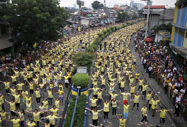 Thousands of health enthusiasts dance to high tempo music as they participate in a Guinness World Records attempt for the largest Zumba class held along the main streets of Mandaluyong city, metro Manila July 19, 2015. Mandaluyong city achieved the Guinness World Records for the largest Zumba class with an official tally of 12, 975 people simultaneously doing Zumba, overthrowing Cebu City's record of 8,232 people held in October 2014, a Guinness World Records official said. (Photo by /Lorgina MinguitoReuters)