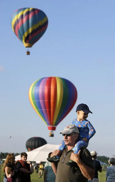Inflated hot air balloons begin lifting off during the 33rd annual QuickChek New Jersey Festival of Ballooning at Solberg Airport Friday, July 24, 2015, in Readington, N.J. (Photo by Mel Evans/AP Photo)