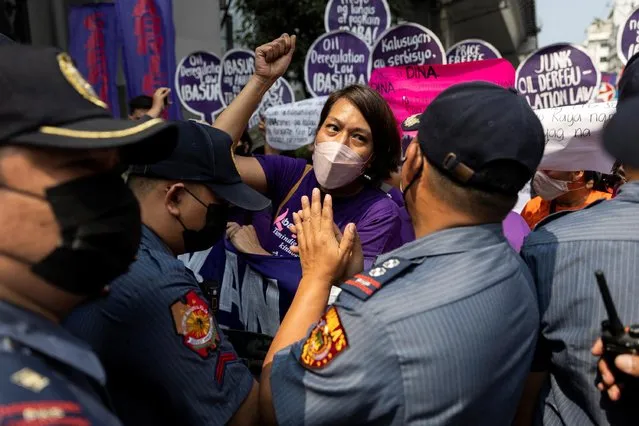 A Filipino woman activist is blocked by police while marching during a protest on International Women's Day, in Manila, Philippines, March 8, 2022. (Photo by Eloisa Lopez/Reuters)
