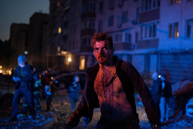 An injured man stands next to an apartment building which was damaged during a massive Russian drone strike in Kyiv, Ukraine on May 30, 2023. (Photo by Pablo Petrov/Press service of the State Emergency Service of Ukraine/Handout via Reuters)