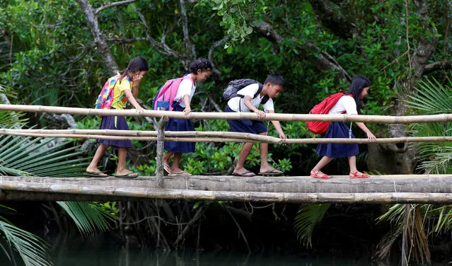 Schoolchildren, who walk six kilometers everyday to attend classes, cross a makeshift foot bridge in a village of Tagumpay in Pola, Oriental Mindoro, central Philippines March 1, 2017. (Photo by Erik De Castro/Reuters)