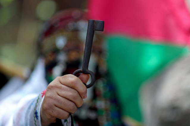 A Palestinian woman holds up a key symbolizing their demand to return to homes they fled or were expelled from in the war that led to the founding of Israel in 1948, during a rally marking the 74th anniversary of Nakba, or catastrophe, in Gaza City on May 15, 2022. (Photo by Mohammed Salem/Reuters)