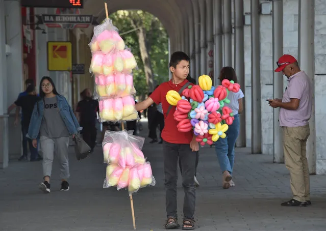 A boy sells sweets and balloons during the celebrations marking the 29th anniversary of Kyrgyzstan's independence from the Soviet Union at the Ala-Too Square in Bishkek on August 31, 2020. (Photo by Vyacheslav Oseledko/AFP Photo)