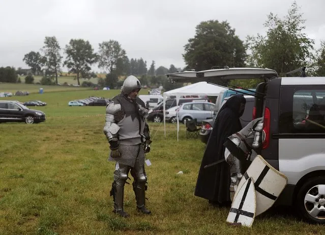 Men dressed as knights of the Teutonic Order prepare to participate in a reenactment of The Battle of Grunwald, in Grunwald July 12, 2014. (Photo by Filip Klimaszewski/Reuters)