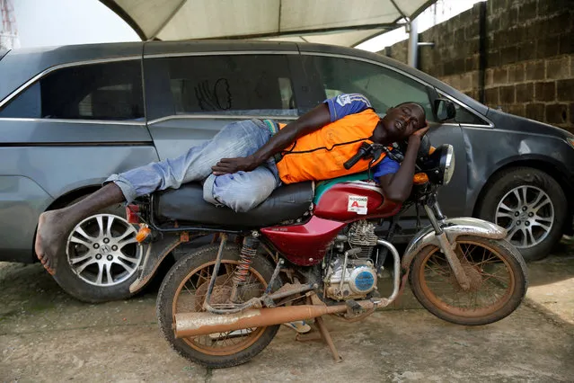 A commercial motorcyclist rests on a motorcycle at Agege district in Lagos, Nigeria June 22, 2016. (Photo by Akintunde Akinleye/Reuters)