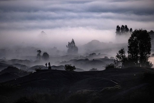 Indonesian Hindus Tenggerese worshippers walk through Mount Bromo valley during the Yadnya Kasada ritual on June 26, 2021 in Probolinggo, Java, Indonesia. The Tenggerese people are an ethnic group in Eastern Java, Indonesia's most populous island, who believe themselves to be descendants of the Majapahit princes that ruled the area historically. Their population of roughly 500,000 is centered in the Bromo Tengger Semeru National Park in eastern Java. The ethnic group's most popular ceremony, the month-long Yadnya Kasada festival, was the most visited tourist attraction in Indonesia before the Covid-19 pandemic. On the fourteenth day, the Tenggerese make a journey to Mount Bromo to make offerings of rice, fruits, vegetables, flowers and even livestock and poultry, throwing them into the volcano's caldera. The ritual is thought to have started in the 15th century, when a local princess and her husband prayed to the mountain gods for help in having children. (Photo by Robertus Pudyanto/Getty Images)