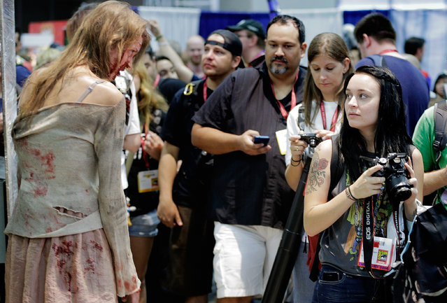 A zombie character from the TV show “The Walking Dead” approaches the attendees during the 45th annual San Diego Comic-Con on July 24, 2014 in San Diego, California. An estimated 130,000 attendees are expected at this year's convention, which will celebrate the 75th anniversary of both Marvel Comics and the first Batman comic book. (Photo by T. J. Kirkpatrick/Getty Images)
