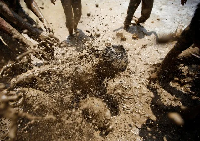 Students of Himalayan Agriculture College play in the mud while celebrating Asar Pandra festival in Lalitpur, Nepal, June 29, 2016. (Photo by Navesh Chitrakar/Reuters)