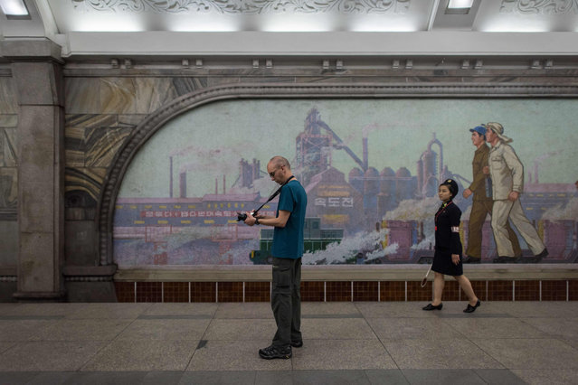 A tourist takes a photo during a visit to a subway station in Pyongyang on July 23, 2017. The Westerners lined up before giant statues of North Korea’s founder Kim Il- Sung and his son and successor Kim Jong- Il on Sunday and, on command from their guide, bowed deeply - a ritual that the Trump administration intends to stop US tourists performing, with Washington due to impose a ban on its citizens holidaying in the Democratic People' s Republic of Korea (DPRK), as the North is officially known. (Photo by Ed Jones/AFP Photo)