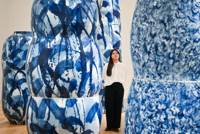 A visitor looks at giant vases and ceramic creations part of the “A forest of Porcelain” installation by British ceramist Felicity Aylieff during a photocall for the exhibition “Expressions in Blue: Monumental Porcelain” at Kew Gardens, in London, on October 24, 2024. The exhibition runs from October 26, 2024 to March 23, 2025. (Photo by Justin Tallis/AFP Photo)