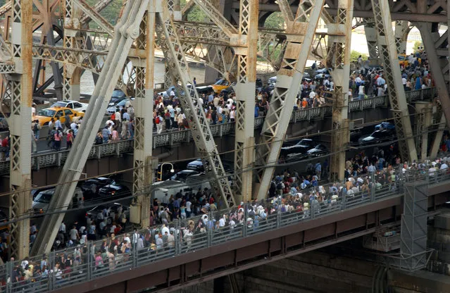 Pedestrians and traffic leaving downtown Manhattan crossing the Queensboro Bridge after the onset of the largest power blackout in American history, August 14, 2003. The Northeast blackout of 2003 was a widespread power outage that occurred throughout parts of the Northeastern and Midwestern United States and the Canadian province of Ontario on Thursday, August 14, 2003, just after 4:10 p.m. EDT. Some power was restored by 11 p.m. Many others did not get their power back until two days later. In more remote areas it took nearly a week to restore power. At the time, it was the world's second most widespread blackout in history, after the 1999 Southern Brazil blackout. The outage, which was much more widespread than the Northeast Blackout of 1965, affected an estimated 10 million people in Ontario and 45 million people in eight U.S. states. The blackout's primary cause was a programming error or “bug” in the alarm system at a FirstEnergy Corporation control room in Ohio. The lack of an alarm left operators unaware of the need to re-distribute power after overloaded transmission lines hit unpruned foliage, triggering a “race condition” in the energy management system software, a bug affecting the order of operations in the system. What would have been a manageable local blackout cascaded into massive widespread distress on the electric grid. (Photo by Robin Platzer/FilmMagic)