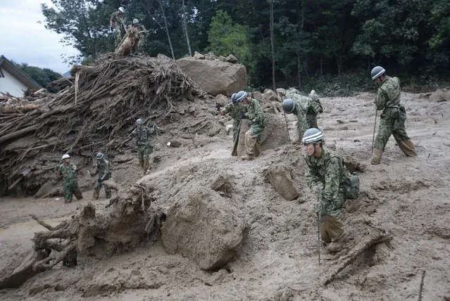 Japan Self-Defense Force soldiers search for survivors at the site of a landslide at Asaminami ward in Hiroshima, August 20, 2014. At least 36 people, including several children, were killed in Japan on Wednesday, when landslides triggered by torrential rain slammed into the outskirts of the western city of Hiroshima, and the toll could rise further, police said. (Photo by Toru Hanai/Reuters)