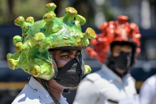 Traffic police personnel wearing coronavirus-themed helmets participate in a campaign to educate the public during a government-imposed nationwide lockdown as a preventive measure against the COVID-19 coronavirus in Bangalore on March 31, 2020. (Photo by Manjunath Kiran/AFP Photo)