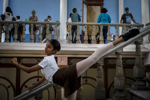 A ballet student poses for a friend to take photos, at the national ballet school in Havana, Cuba, Thursday, December 12, 2019. The Soviet-style system that recruits children into a system of increasingly selective state dance schools has produced hundreds of elite dancers including Lorna Feijoo, Rolando Sarabia, Taras Domitro, Anette Delgado and Carlos Acosta. (Photo by Ramon Espinosa/AP Photo)
