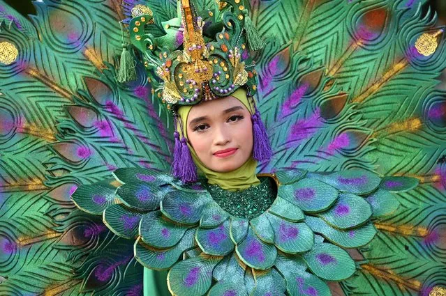 A youth participates in a cultural carnival street parade to celebrate the country's 77th Indonesia's Independence Day in Banda Aceh on August 18, 2022. (Photo by Chaideer Mahyuddin/AFP Photo)